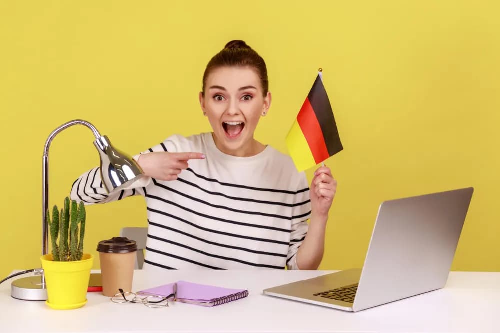 A happy learner holding a German flag